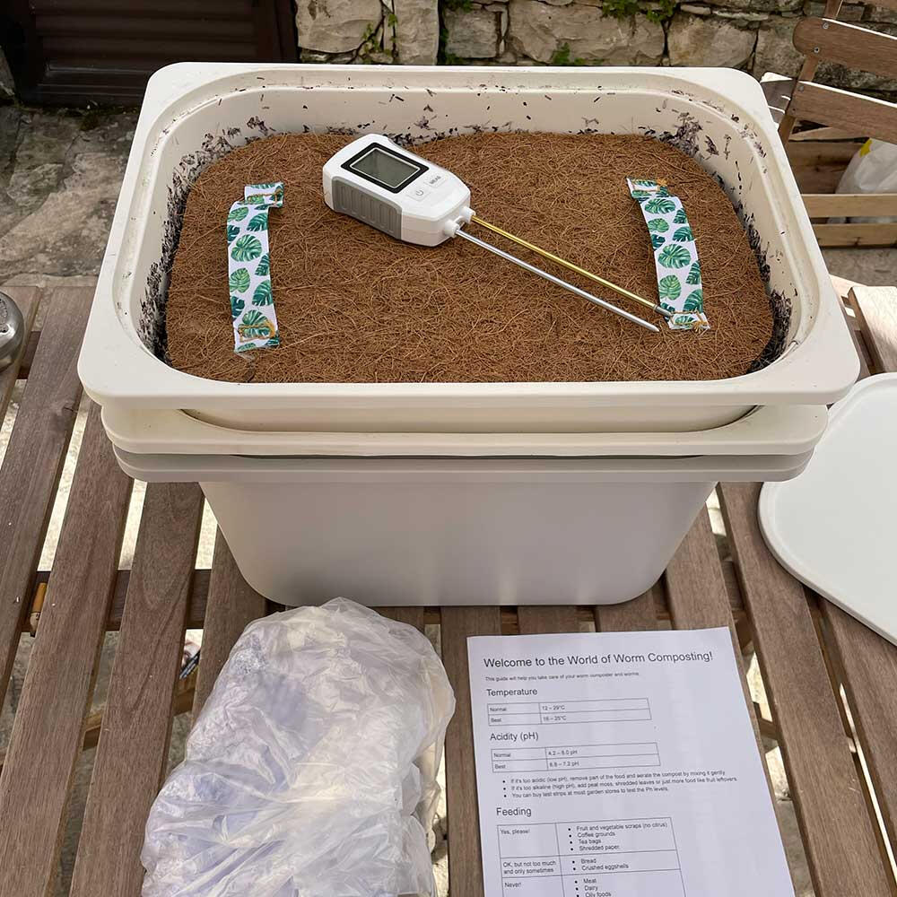 Advanced worm composting kit with thermometer, pH meter, worm blanket, and additional accessories arranged on a table